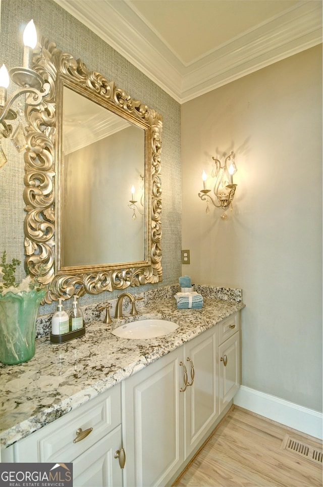 bathroom with visible vents, wood finished floors, crown molding, baseboards, and vanity