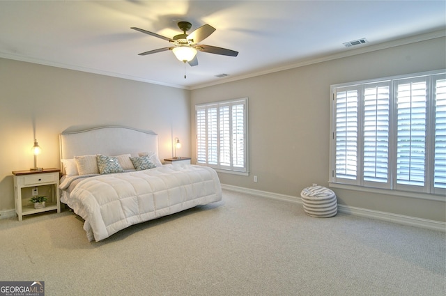 carpeted bedroom with visible vents, baseboards, a ceiling fan, and crown molding