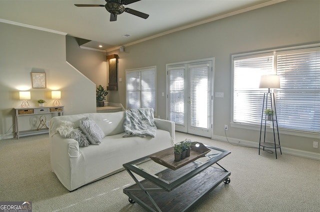 carpeted living area with baseboards, ceiling fan, and crown molding