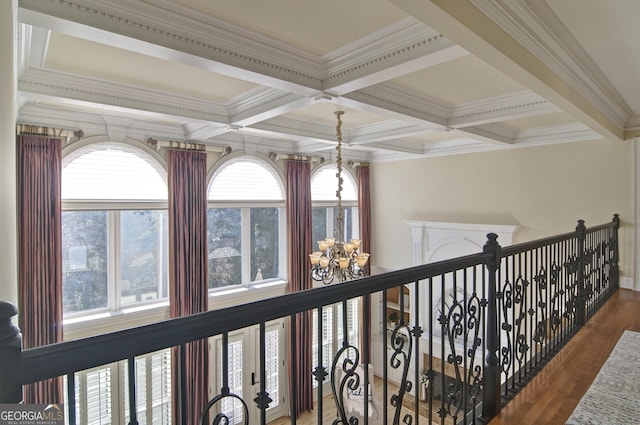 hallway with a chandelier, beamed ceiling, coffered ceiling, and wood finished floors