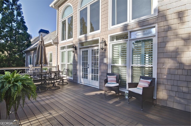 deck featuring outdoor dining space and french doors