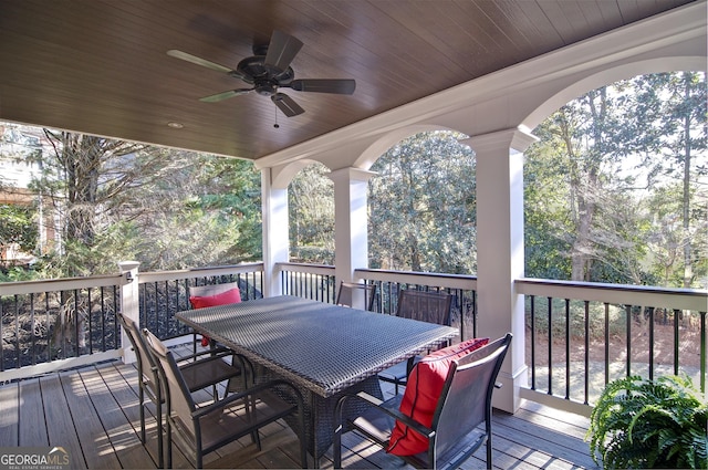 wooden terrace featuring outdoor dining space and a ceiling fan