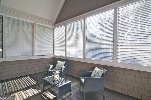 sunroom featuring lofted ceiling and a healthy amount of sunlight