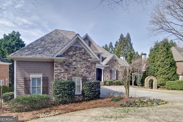 view of front of house featuring stone siding and driveway