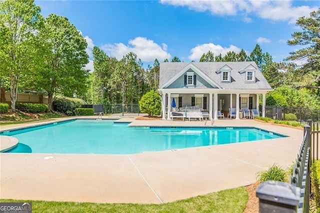 back of house with a patio area, a community pool, and fence