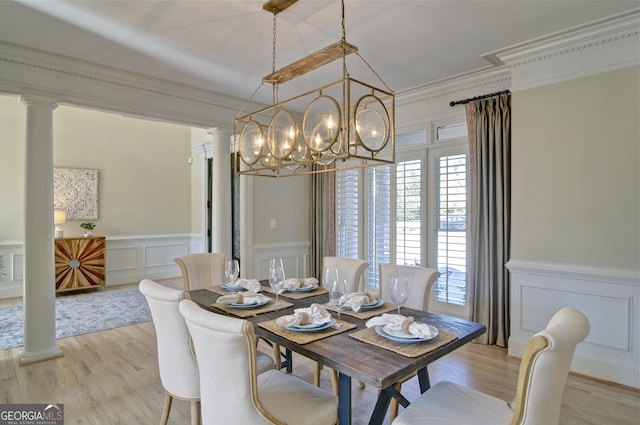 dining space with ornamental molding, light wood-style floors, ornate columns, and a chandelier