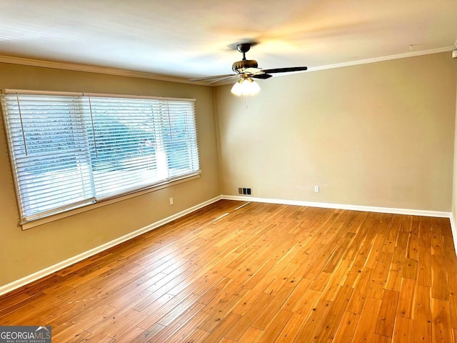 spare room with ornamental molding, light wood-type flooring, visible vents, and baseboards