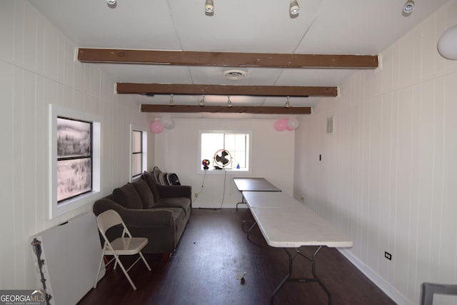 living room with visible vents, dark wood-style flooring, and beam ceiling