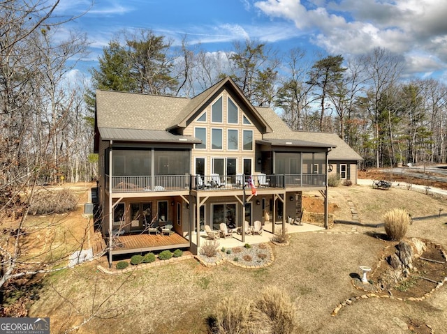 back of house with a sunroom, a patio, and a wooden deck