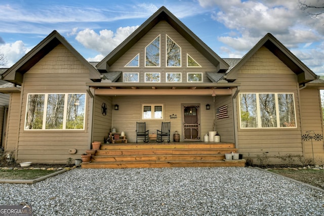 back of property featuring a porch and roof with shingles