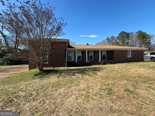 view of front of home with brick siding and a front yard