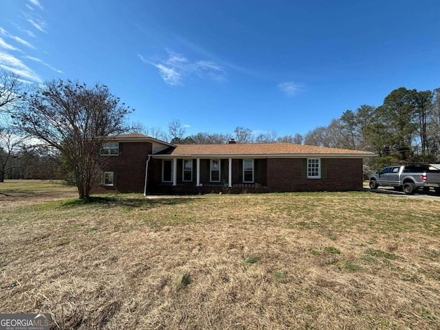 view of front of home with a front lawn and brick siding