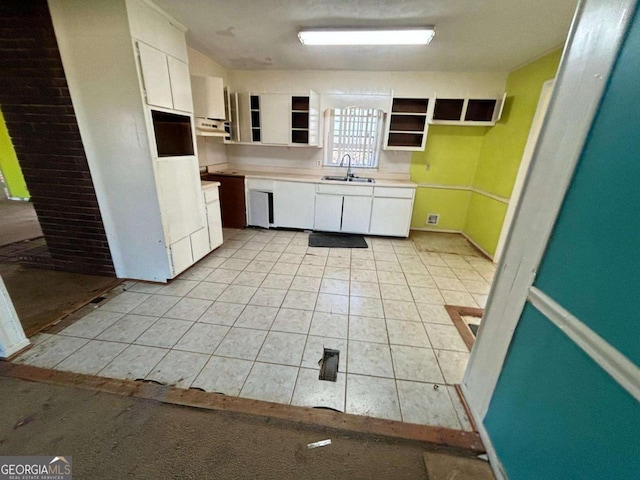 kitchen with a sink, white cabinets, and light countertops