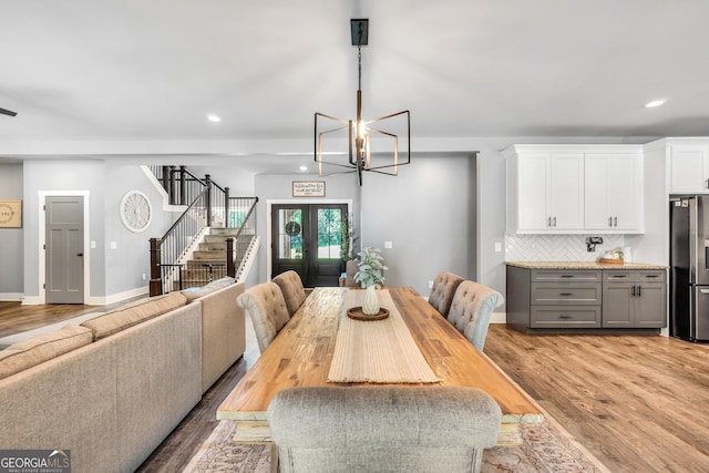 dining room with light wood-style flooring, recessed lighting, baseboards, french doors, and stairway