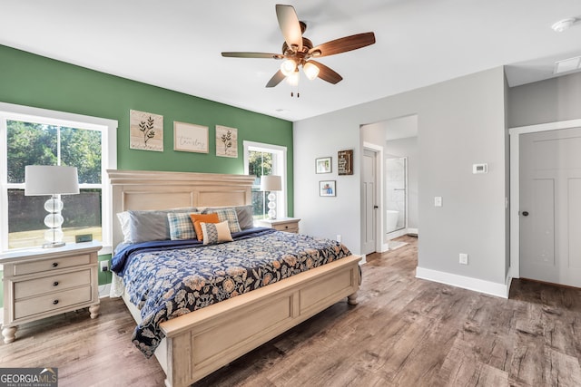 bedroom featuring ceiling fan, visible vents, baseboards, and wood finished floors