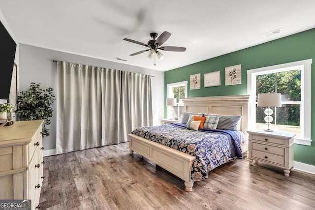 bedroom with visible vents, baseboards, and wood finished floors