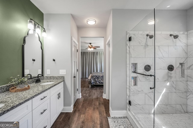 ensuite bathroom featuring baseboards, ensuite bath, wood finished floors, vanity, and a shower stall