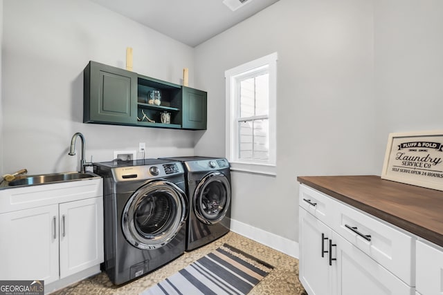 clothes washing area with cabinet space, visible vents, baseboards, washing machine and dryer, and a sink