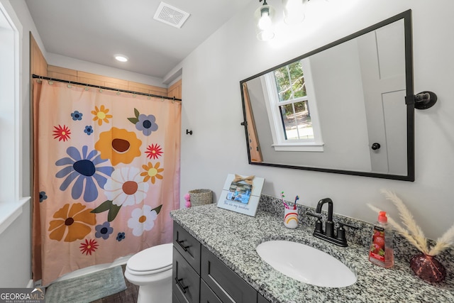 full bathroom featuring toilet, curtained shower, vanity, and visible vents