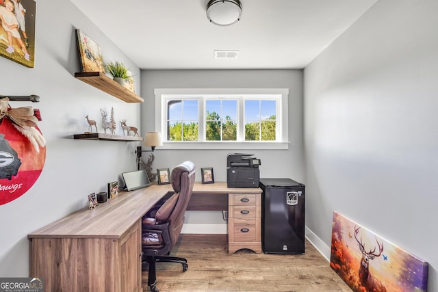 office area with baseboards, visible vents, and light wood finished floors