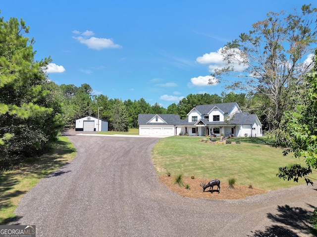 view of front of home with an outbuilding, a detached garage, driveway, and a front lawn