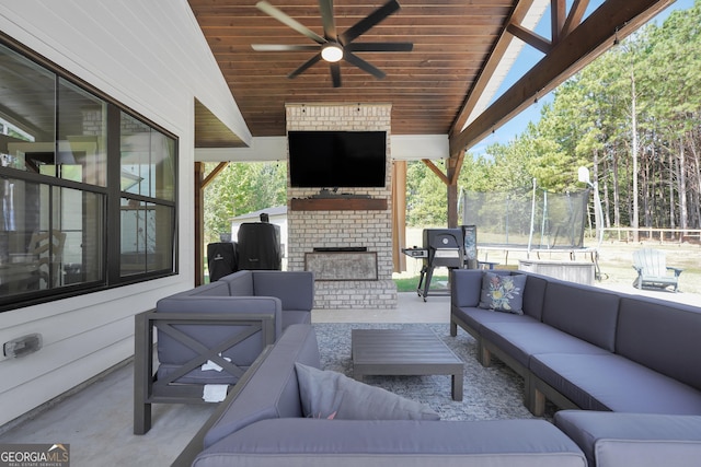 view of patio / terrace featuring an outdoor living space with a fireplace and a ceiling fan