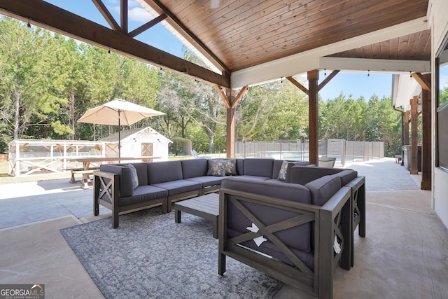 view of patio with a shed, an outdoor living space, a fenced backyard, and an outdoor structure