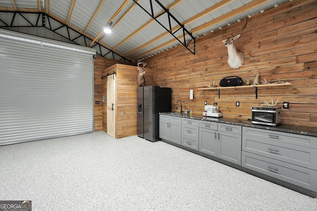 garage with stainless steel fridge, a sink, and metal wall