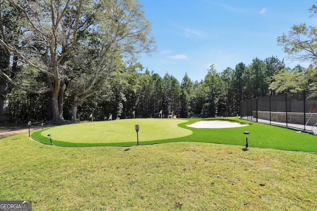 view of community with view of golf course and fence