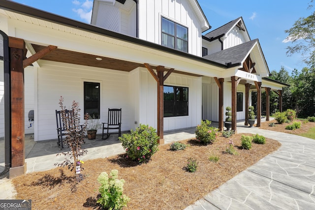 view of front of property with board and batten siding, covered porch, and a shingled roof