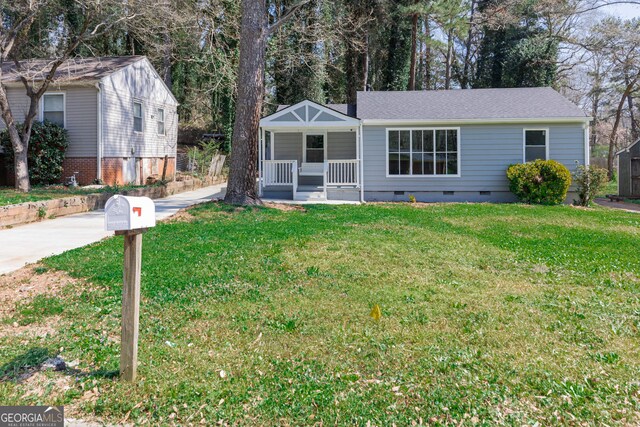 ranch-style home featuring crawl space, covered porch, and a front lawn