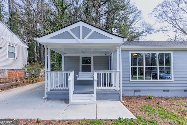 view of front of property with crawl space, a porch, and roof with shingles