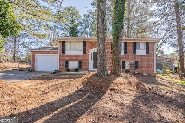 split foyer home featuring a garage, concrete driveway, and brick siding