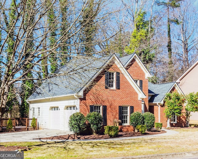 traditional-style home with a garage, brick siding, driveway, roof with shingles, and a front lawn