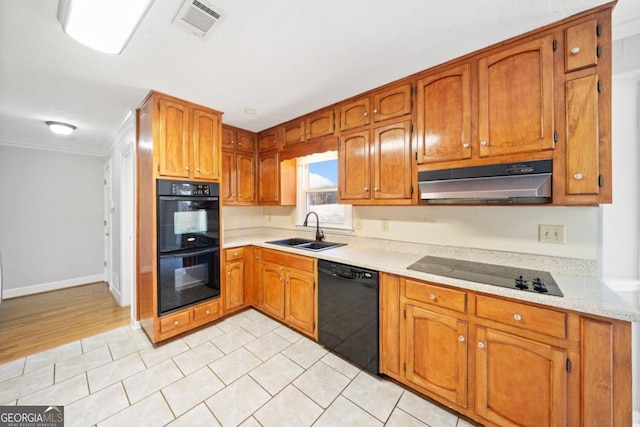 kitchen featuring visible vents, under cabinet range hood, light countertops, black appliances, and a sink