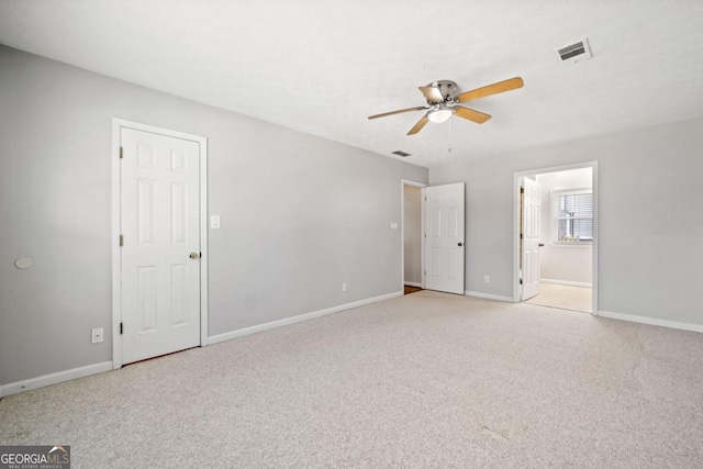 unfurnished bedroom featuring baseboards, connected bathroom, visible vents, and light colored carpet