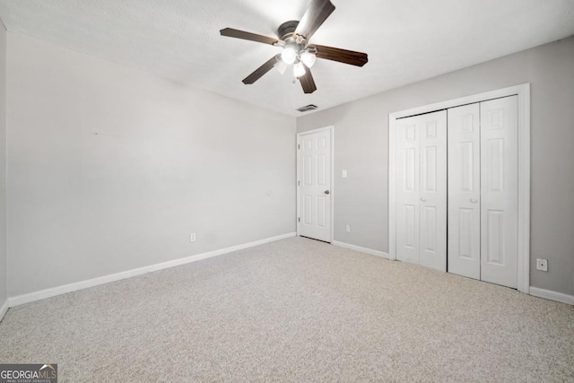 unfurnished bedroom with baseboards, a closet, visible vents, and carpet flooring