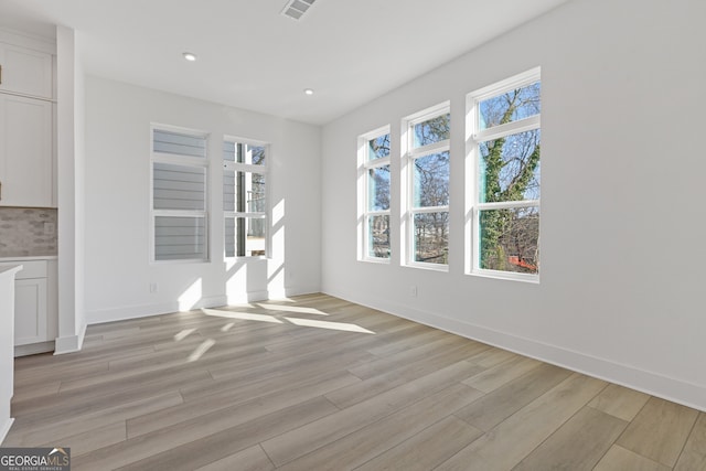 interior space featuring light wood-style floors, recessed lighting, visible vents, and baseboards