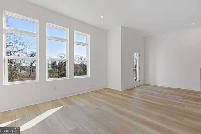 unfurnished room featuring light wood-type flooring, baseboards, and recessed lighting