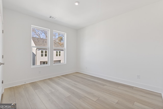 unfurnished room with baseboards, visible vents, and light wood finished floors