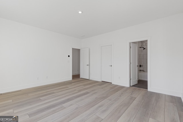 unfurnished bedroom featuring light wood-type flooring, recessed lighting, baseboards, and ensuite bathroom