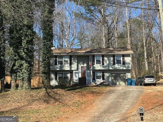 raised ranch with driveway and an attached garage