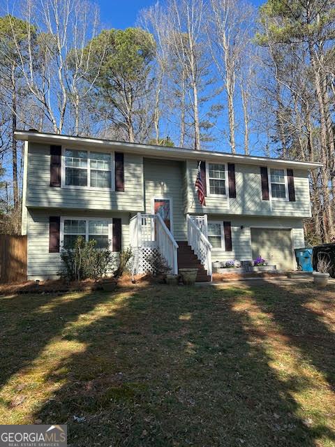 bi-level home with a garage and a front yard