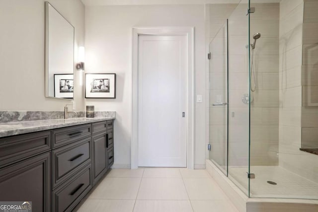 bathroom featuring tile patterned flooring, a stall shower, vanity, and baseboards