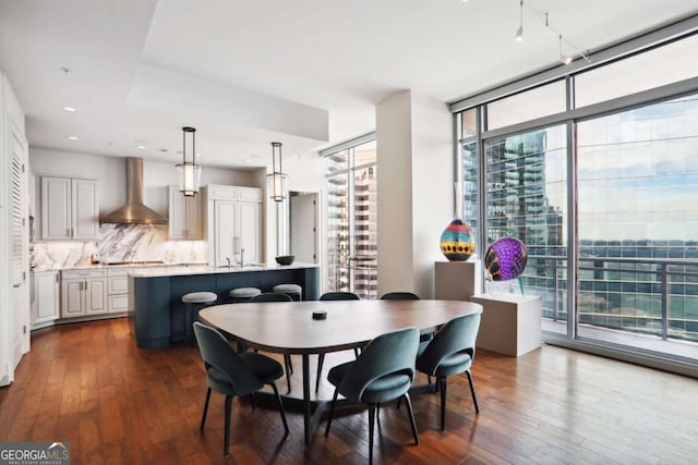 dining room featuring recessed lighting, dark wood-style floors, a wealth of natural light, and expansive windows