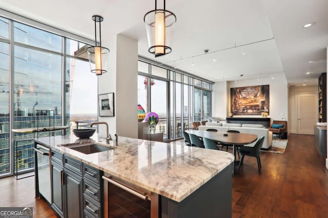 kitchen featuring dark wood-type flooring, beverage cooler, open floor plan, expansive windows, and a sink