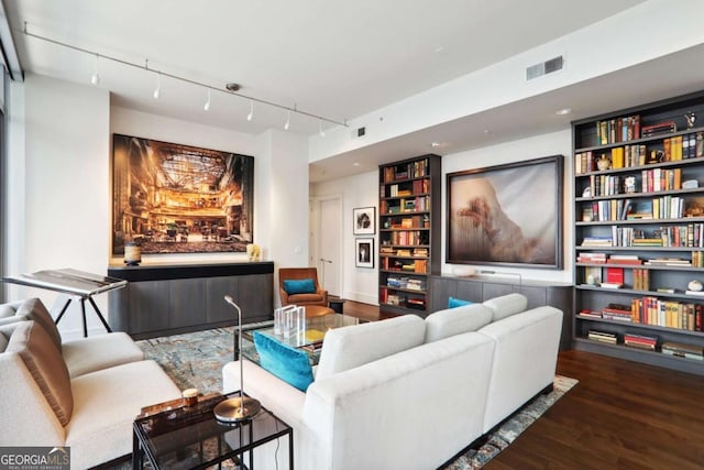 cinema room with visible vents, track lighting, and wood finished floors