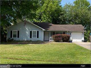 ranch-style house featuring a front lawn, driveway, and an attached garage