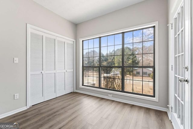 unfurnished bedroom with a closet, baseboards, and wood finished floors