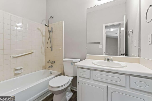 bathroom with bathing tub / shower combination, toilet, and vanity